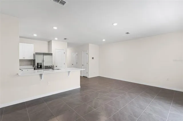 a large white kitchen with kitchen island a sink a stove and a refrigerator
