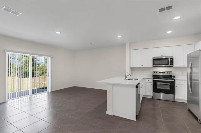 a kitchen with stainless steel appliances a stove a refrigerator and a sink