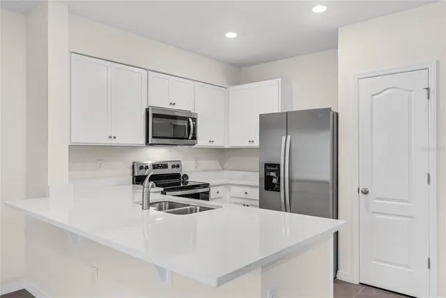 a kitchen with stainless steel appliances a refrigerator a stove a microwave and sink
