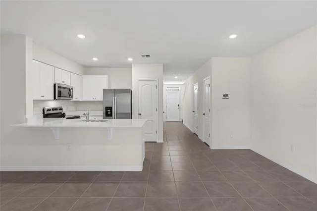 a large white kitchen with stainless steel appliances