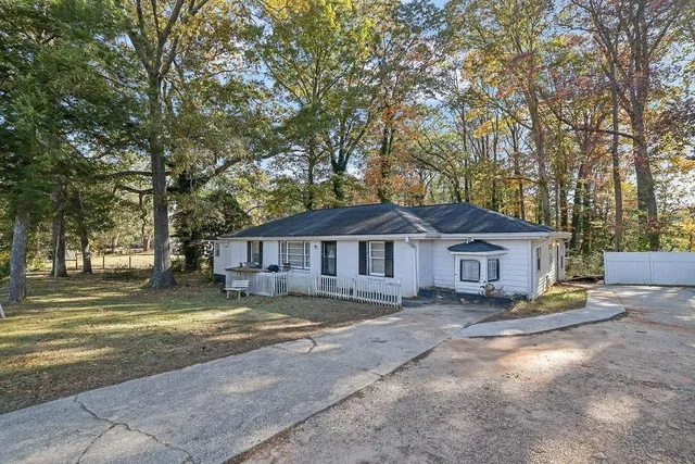 a view of a house with a large tree in front of it