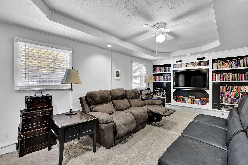 804 Rowland Road Stone Mountain, GA 30083 - Photo 13 of 23 a living room with furniture a ceiling fan and a book shelf