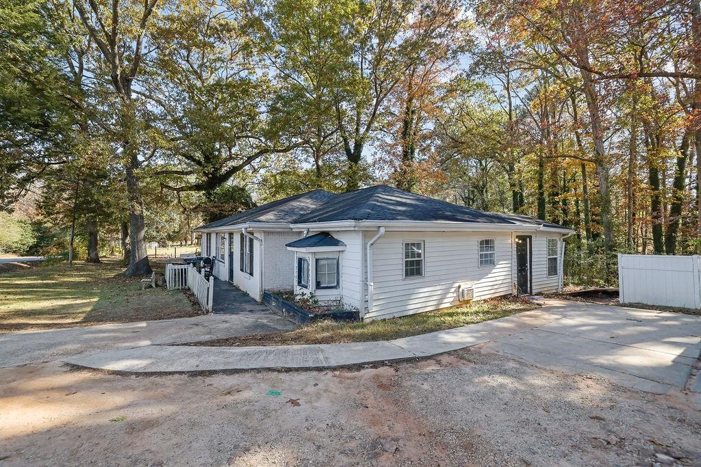 804 Rowland Road Stone Mountain, GA 30083 - Photo 4 of 23 a view of a house with a big yard and large trees