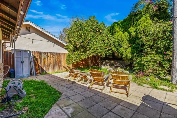 a view of a chair and table in backyard of the house