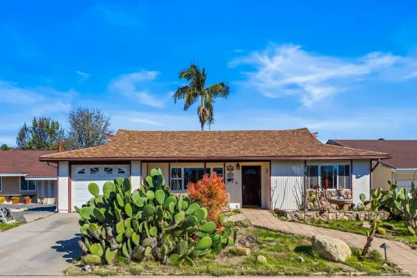 a front view of a house with a garden