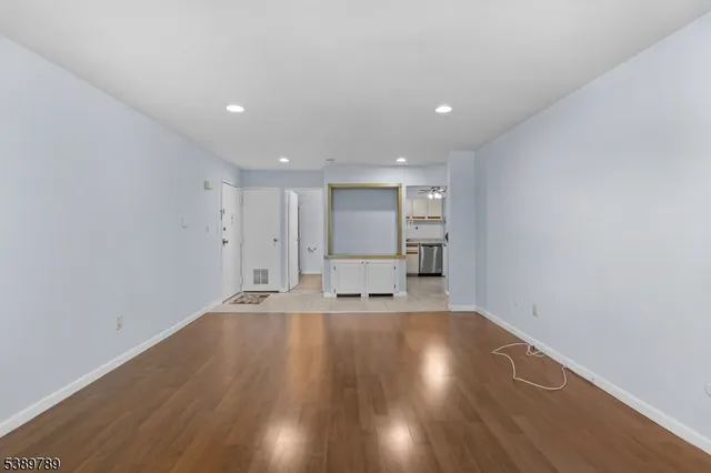 a view of empty room with wooden floor