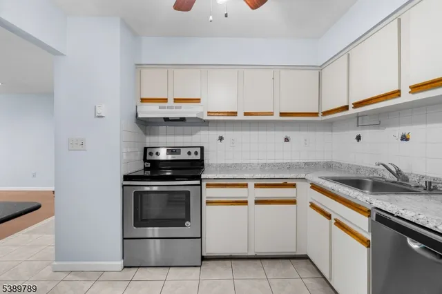 a kitchen with granite countertop white cabinets and white appliances