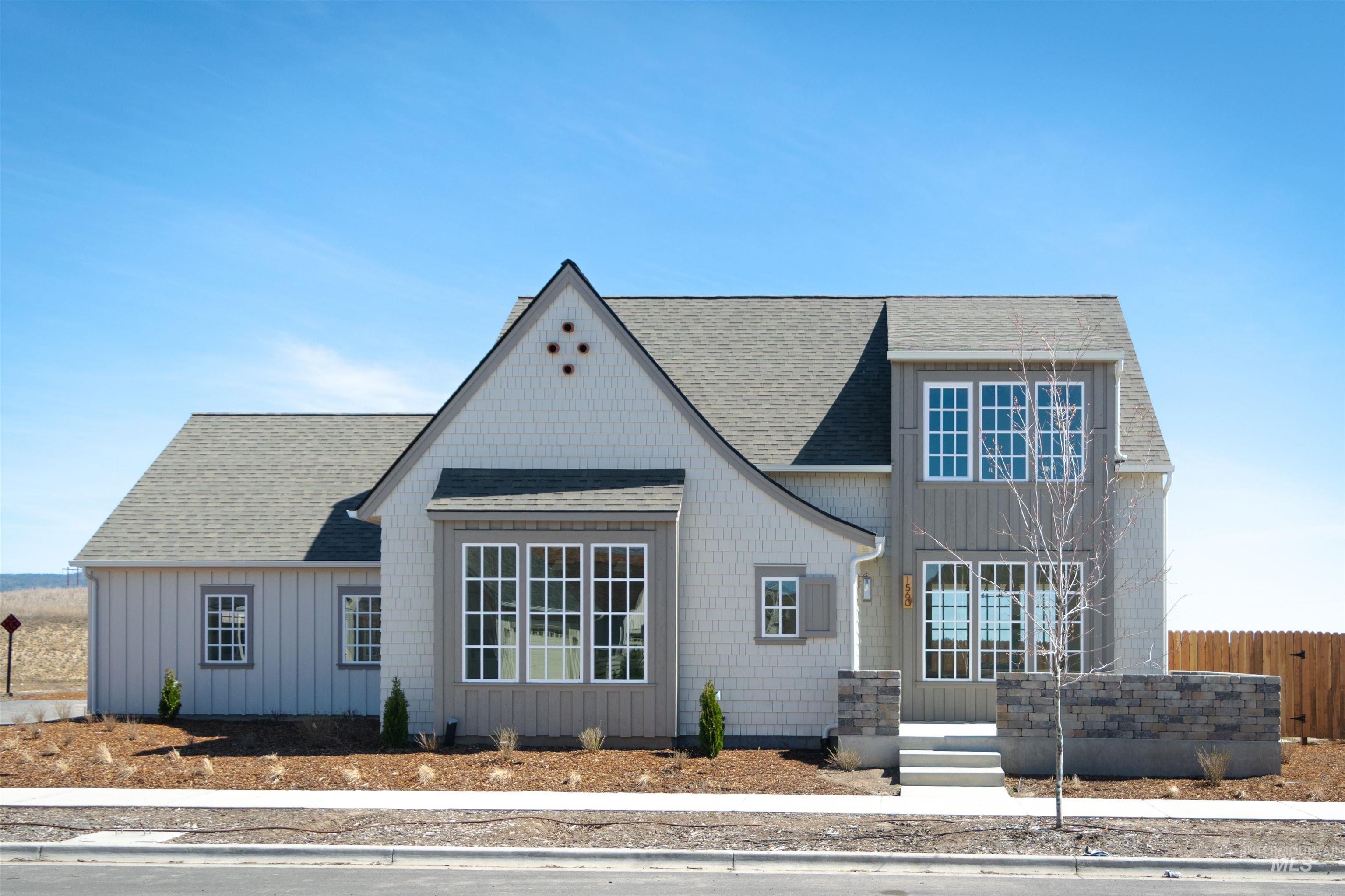 View of front of home with a shingled roof and board and batten siding