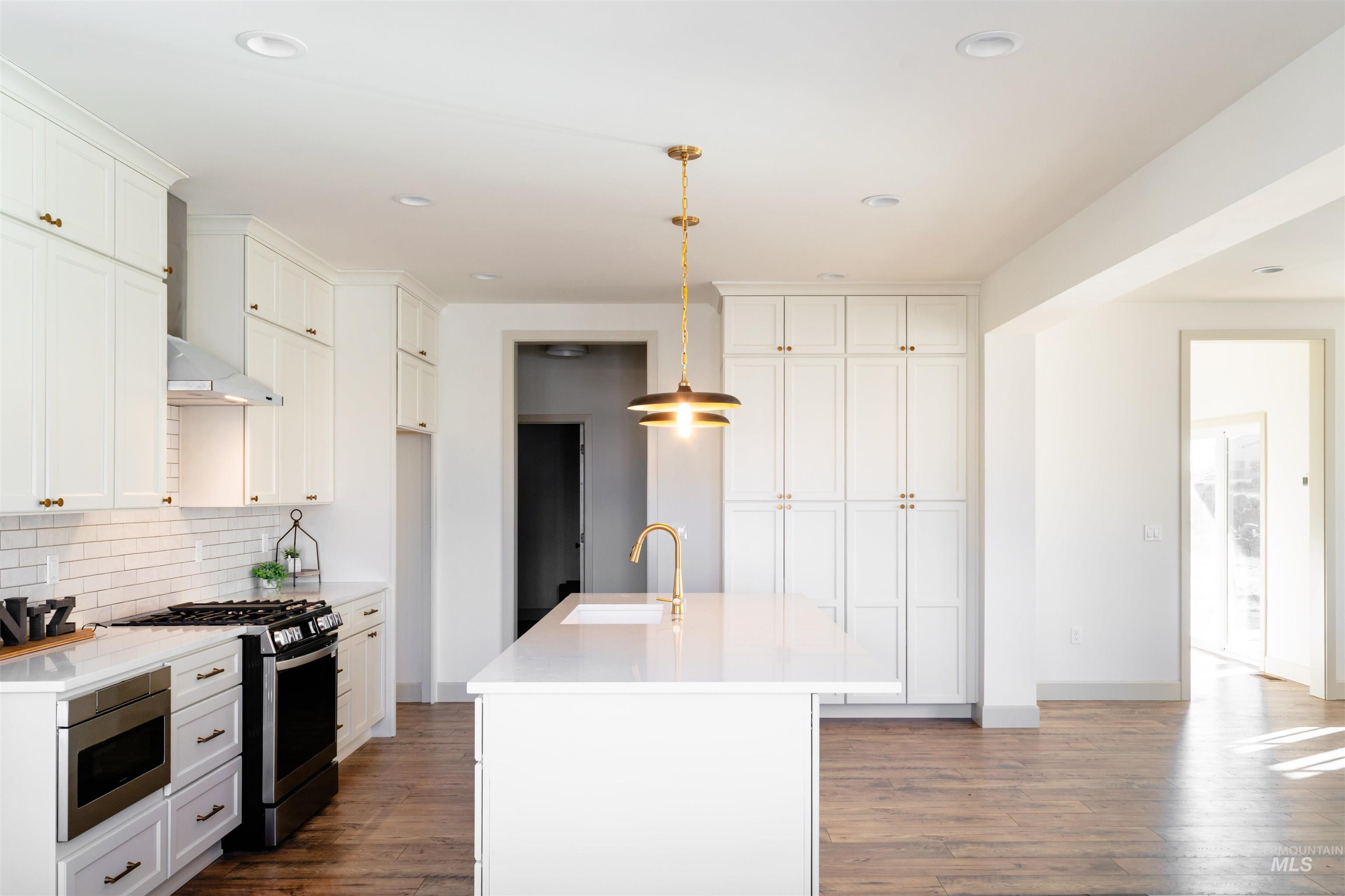 1560 Slonaker, Unit ONYX Moscow, ID 83843 - Photo 15 of 45 Kitchen with stainless steel appliances, hanging light fixtures, dark wood-style flooring, and backsplash