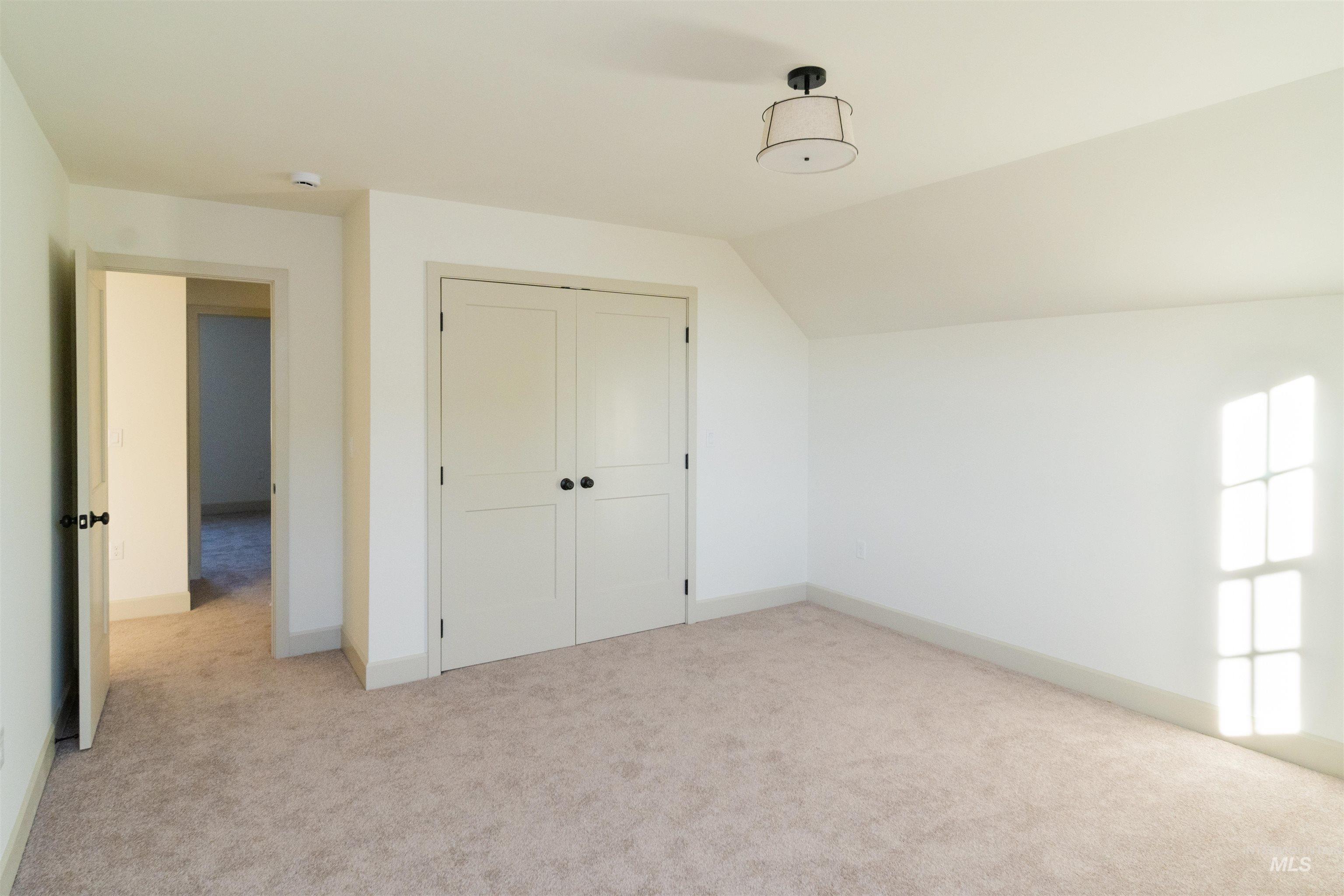 1560 Slonaker, Unit ONYX Moscow, ID 83843 - Photo 20 of 45 Unfurnished bedroom featuring light carpet, vaulted ceiling, and a closet