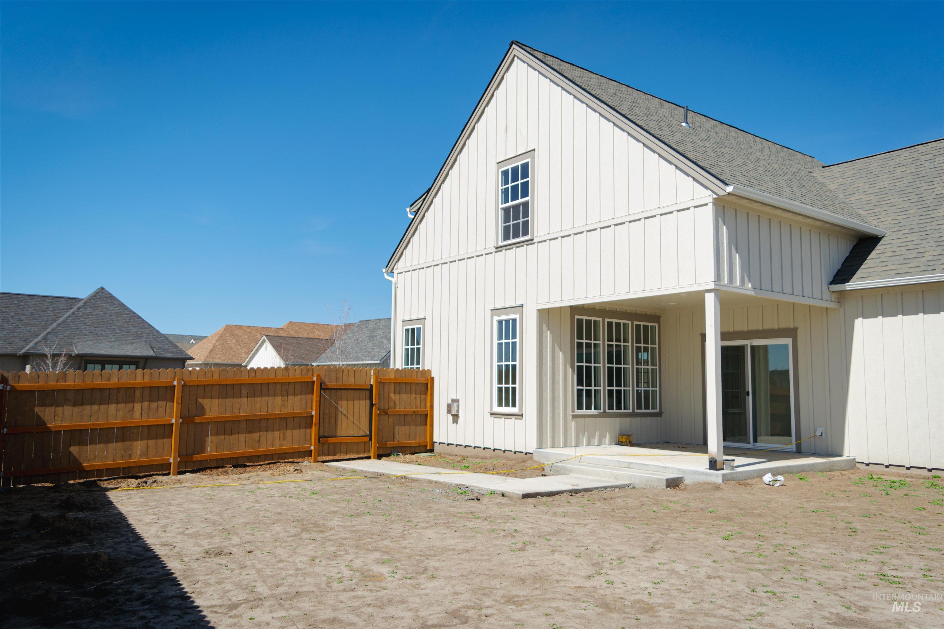 1560 Slonaker, Unit ONYX Moscow, ID 83843 - Photo 25 of 45 Rear view of house with board and batten siding, a gate, roof with shingles, a fenced backyard, and a patio