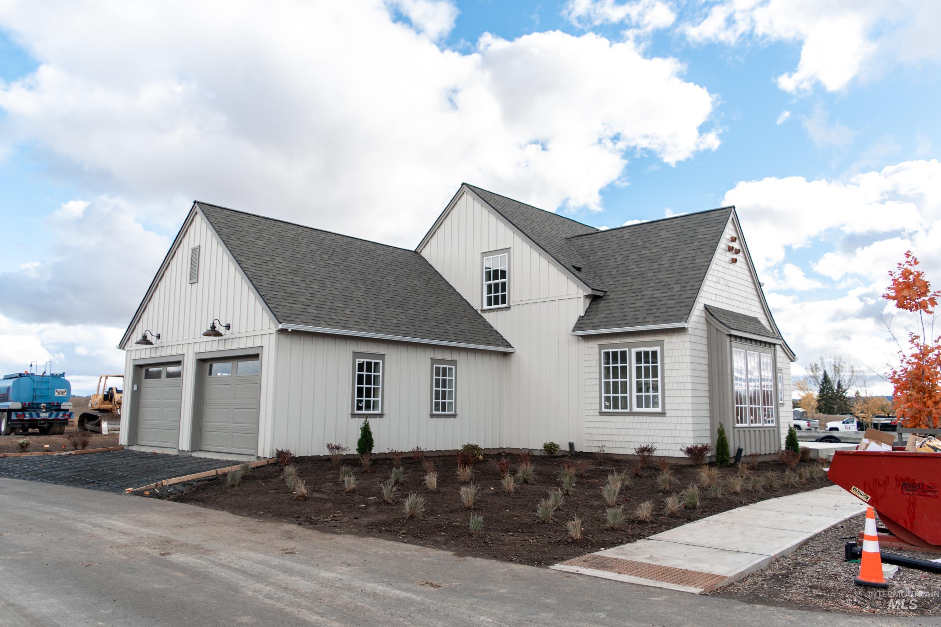 1560 Slonaker, Unit ONYX Moscow, ID 83843 - Photo 4 of 49 View of side of home with a shingled roof, driveway, and board and batten siding