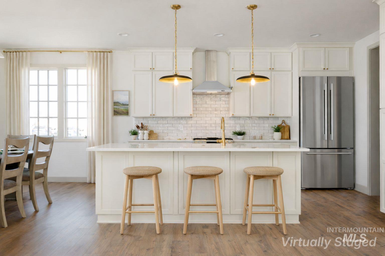 1560 Slonaker, Unit ONYX Moscow, ID 83843 - Photo 5 of 45 Kitchen with freestanding refrigerator, a breakfast bar area, a kitchen island with sink, light wood-style floors, and hanging light fixtures