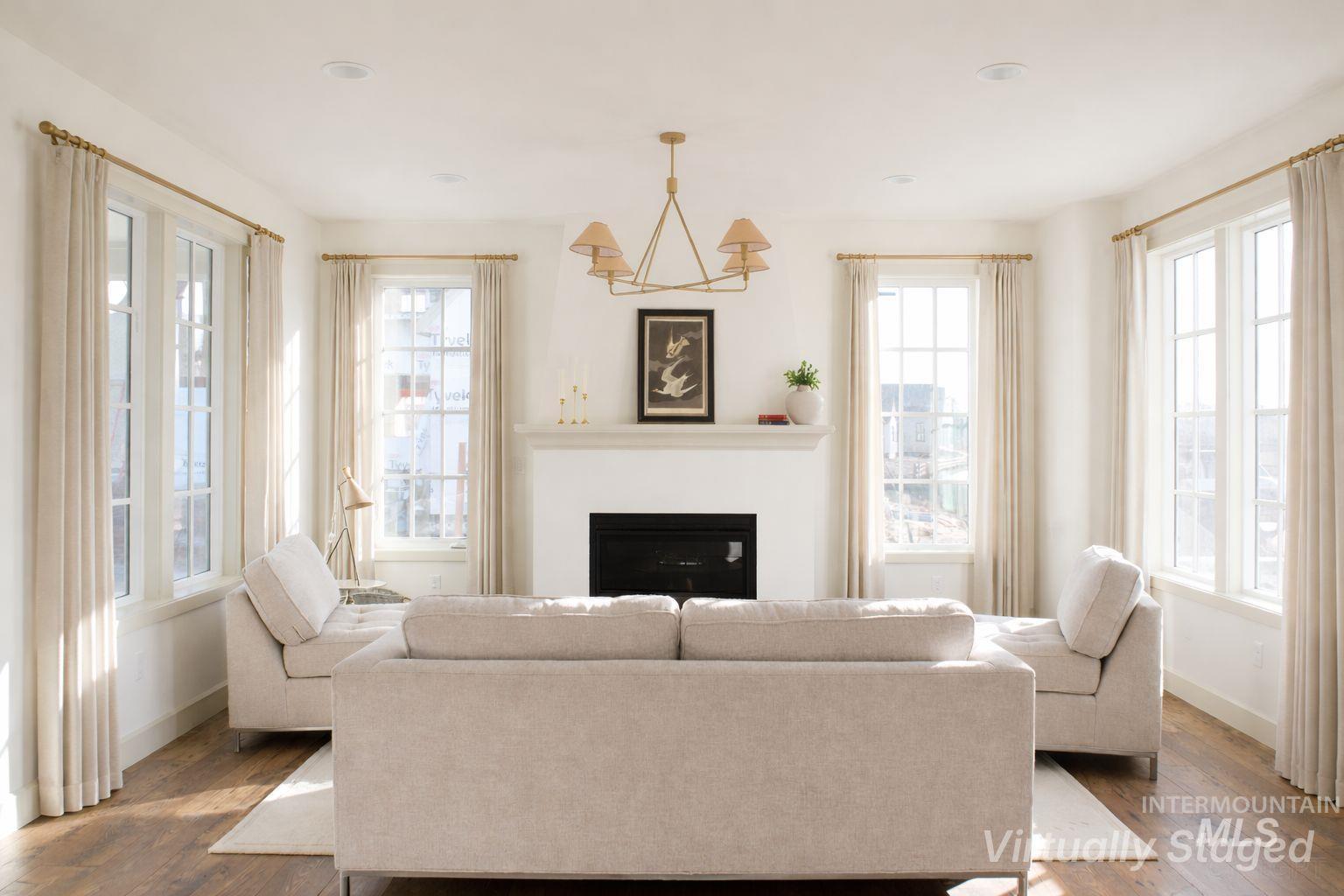 1560 Slonaker, Unit ONYX Moscow, ID 83843 - Photo 5 of 43 Living room featuring a glass covered fireplace, dark wood-style flooring, and a chandelier
