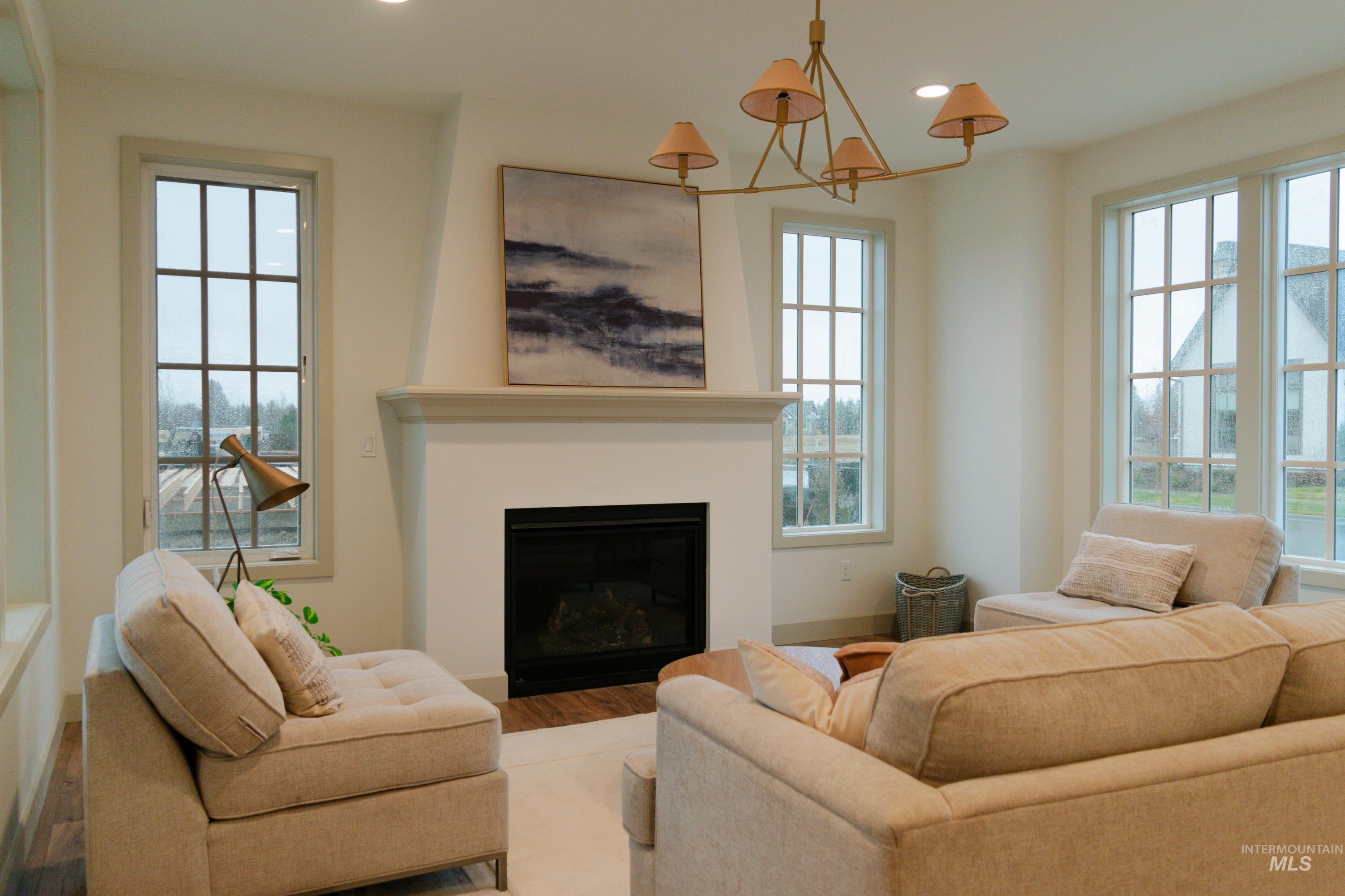 1560 Slonaker, Unit ONYX Moscow, ID 83843 - Photo 6 of 49 Living room with a glass covered fireplace, recessed lighting, wood finished floors, and healthy amount of natural light