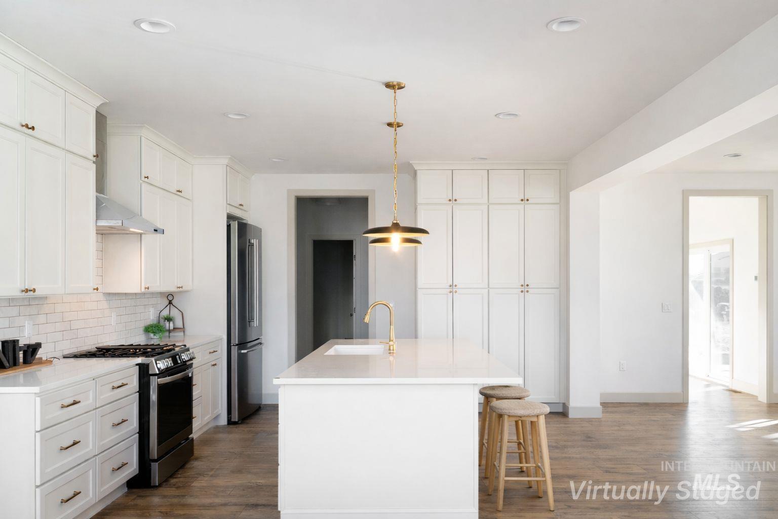 1560 Slonaker, Unit ONYX Moscow, ID 83843 - Photo 7 of 43 Kitchen with stainless steel appliances, decorative light fixtures, a breakfast bar, and dark wood finished floors