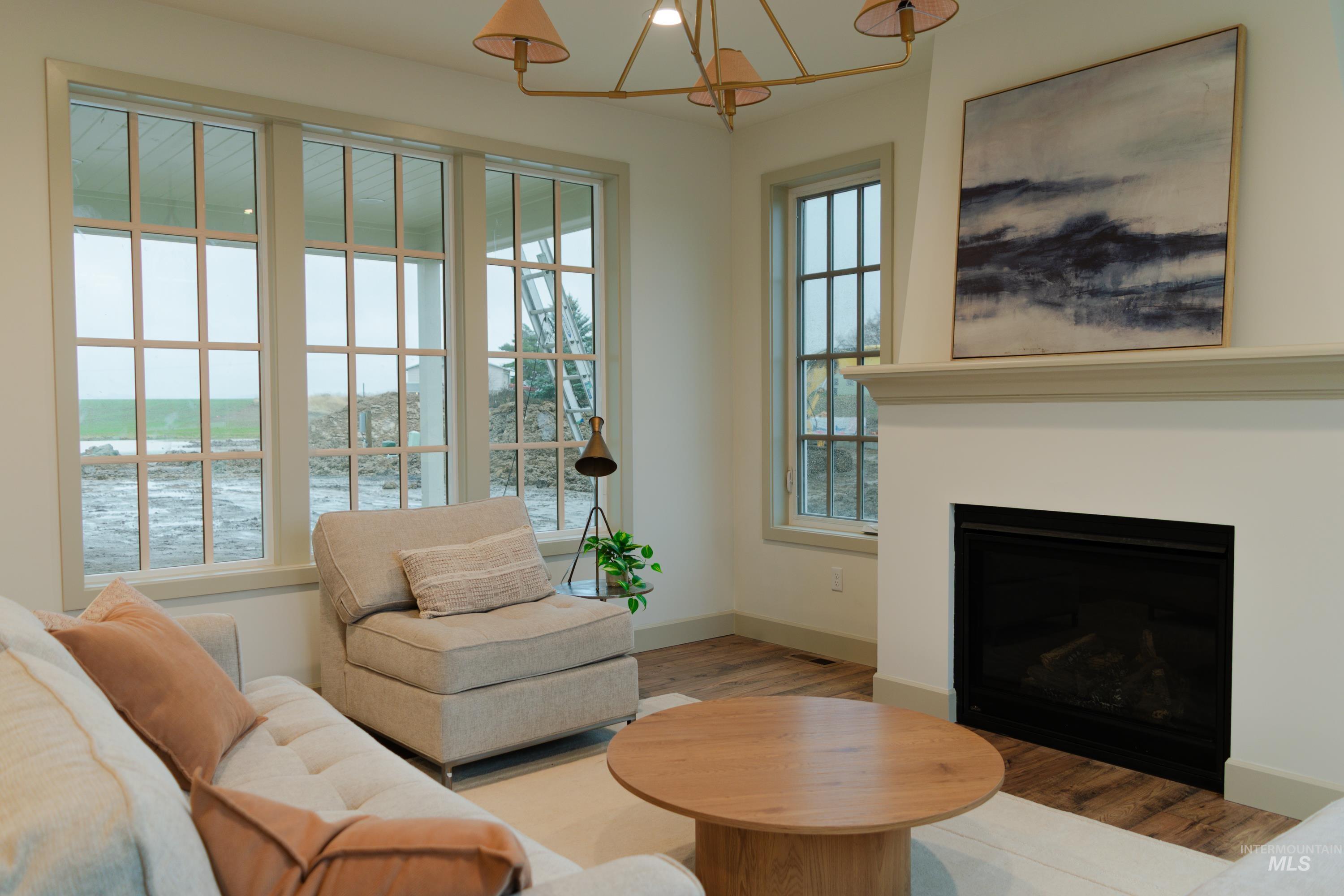 1560 Slonaker, Unit ONYX Moscow, ID 83843 - Photo 7 of 49 Living area with a fireplace with flush hearth, a chandelier, wood finished floors, and a water view