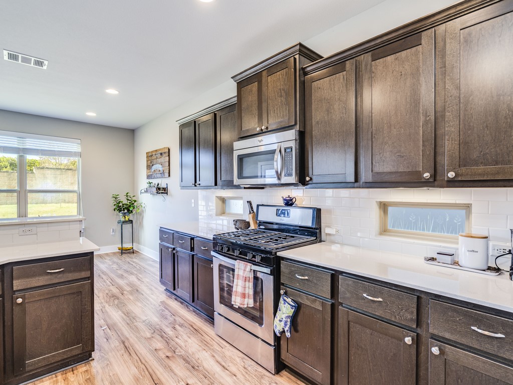 9500 Hunter Lane Austin, TX 78748 - Photo 9 of 25 a kitchen with stainless steel appliances granite countertop a stove a sink and a microwave
