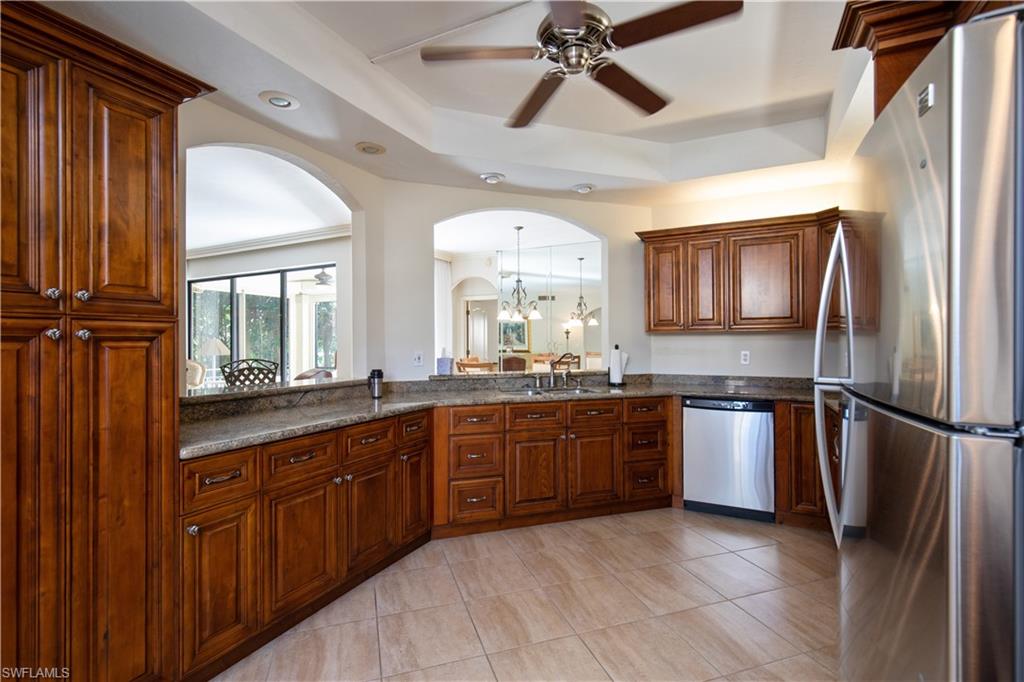 a large kitchen with stainless steel appliances granite countertop a refrigerator and a sink