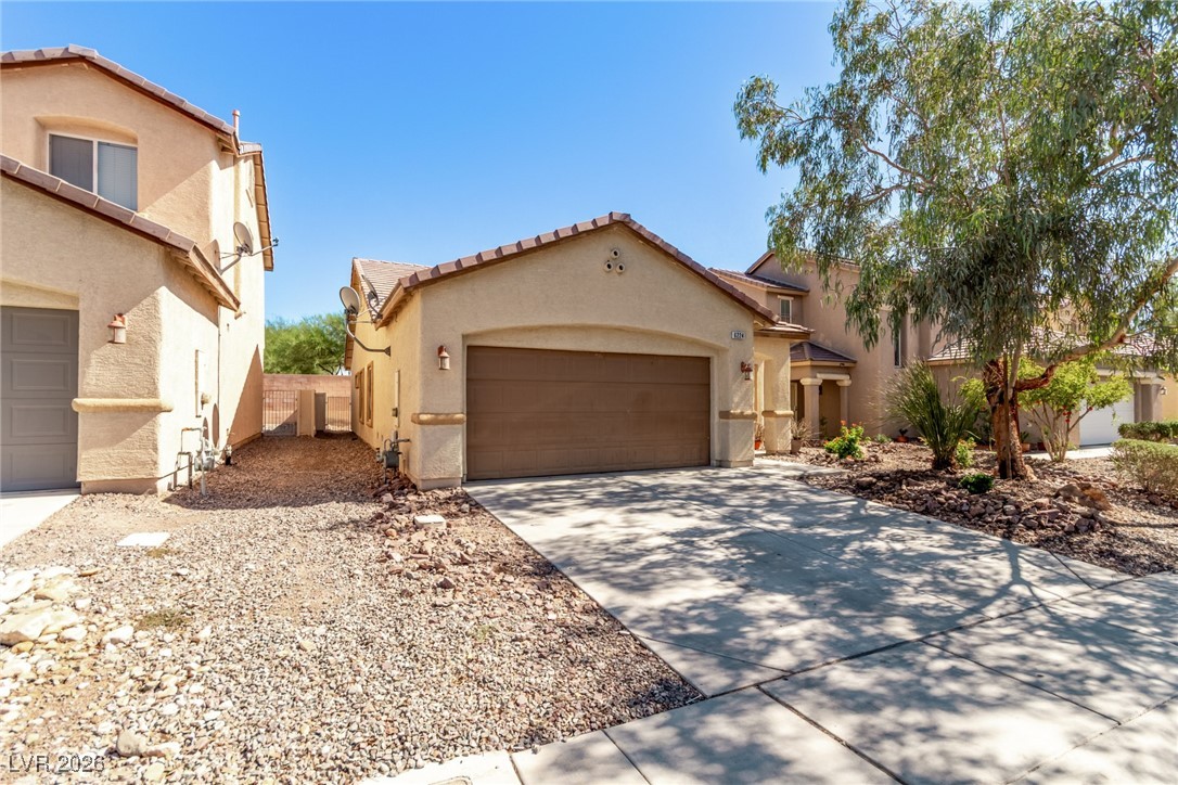 6224 Boulder Rise Street North Las Vegas, NV 89115 - Photo 2 of 27 Mediterranean / spanish-style house with stucco siding, concrete driveway, a tile roof, and an attached garage