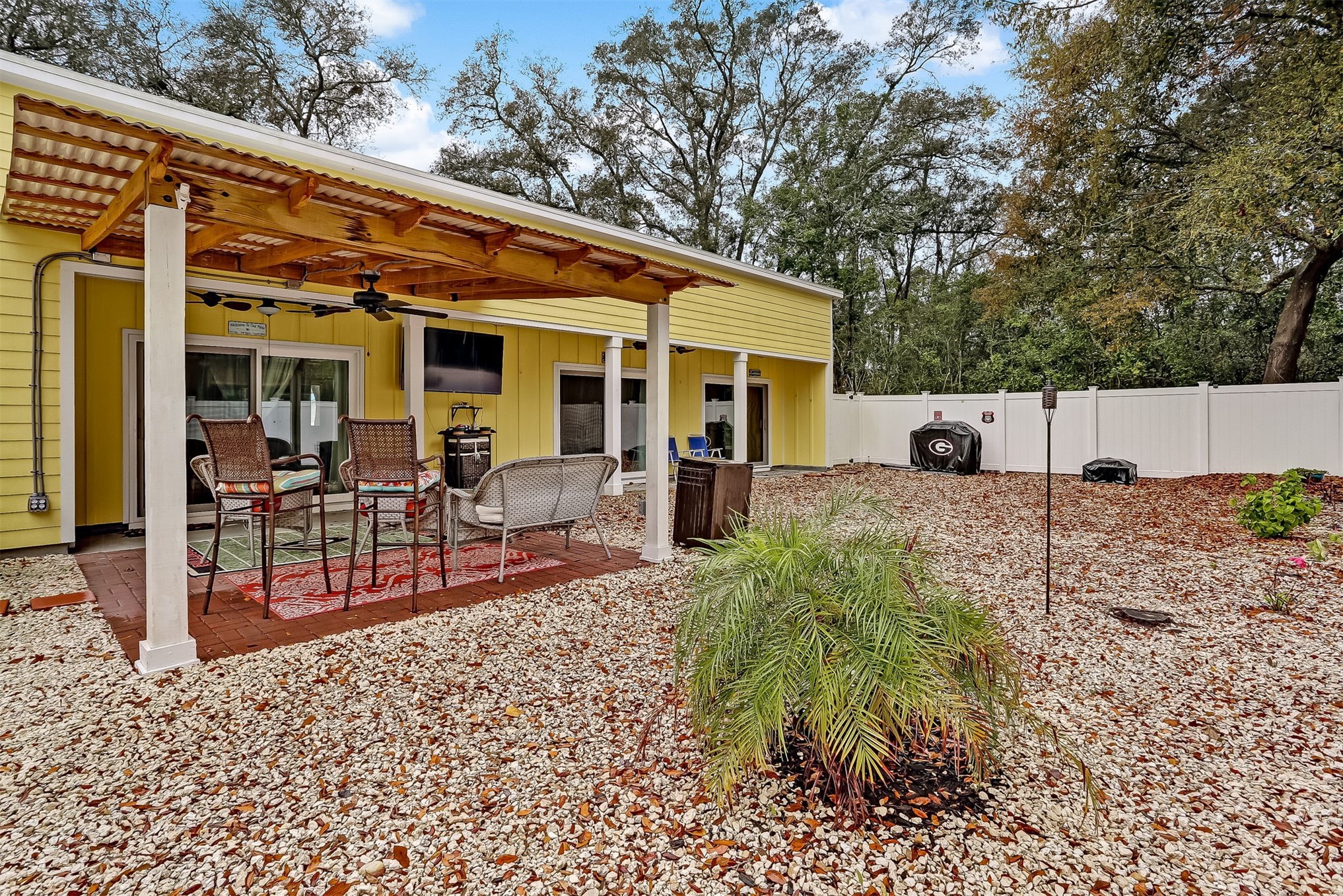 1421 Hickory Street Fernandina Beach, FL 32034 - Photo 16 of 22 a view of a patio with table and chairs a barbeque with potted plants and large tree