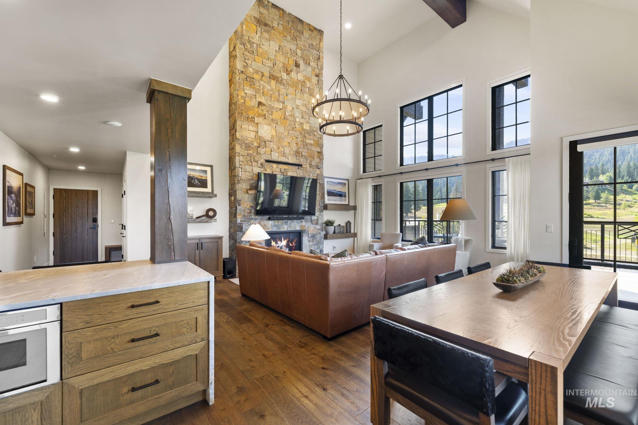 700 Village Drive, Unit 403 Donnelly, ID 83615 - Photo 8 of 43 Dining space featuring a fireplace, dark wood finished floors, a chandelier, beamed ceiling, and recessed lighting