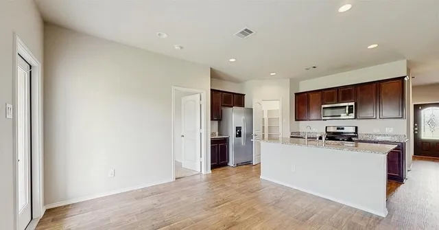a kitchen with a refrigerator and a stove top oven