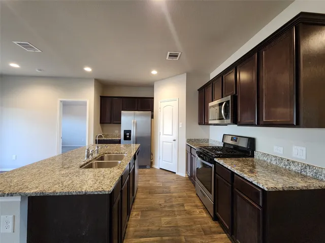 a kitchen with stainless steel appliances granite countertop a sink stove and refrigerator