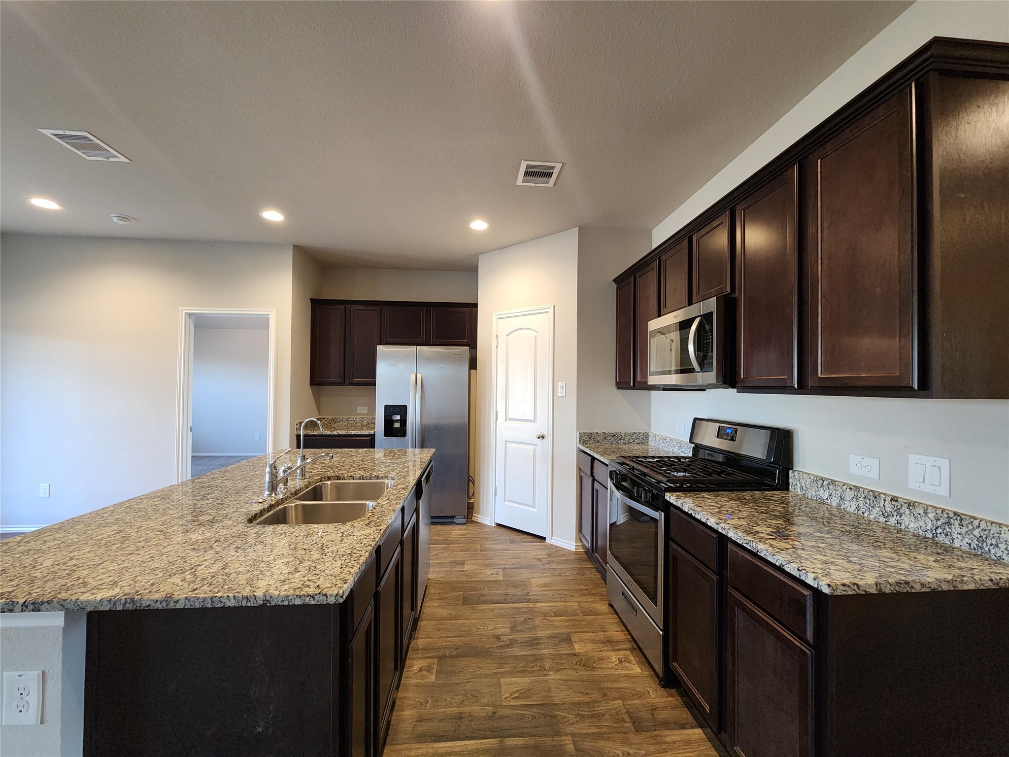 18277 Eaton Mill Drive New Caney, TX 77357 - Photo 10 of 28 a kitchen with stainless steel appliances granite countertop a sink stove and refrigerator