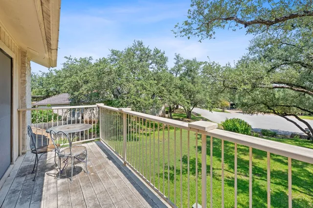 a view of a balcony with wooden floor and fence