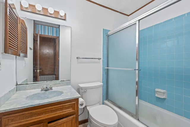 a bathroom with a granite countertop toilet a sink and a mirror