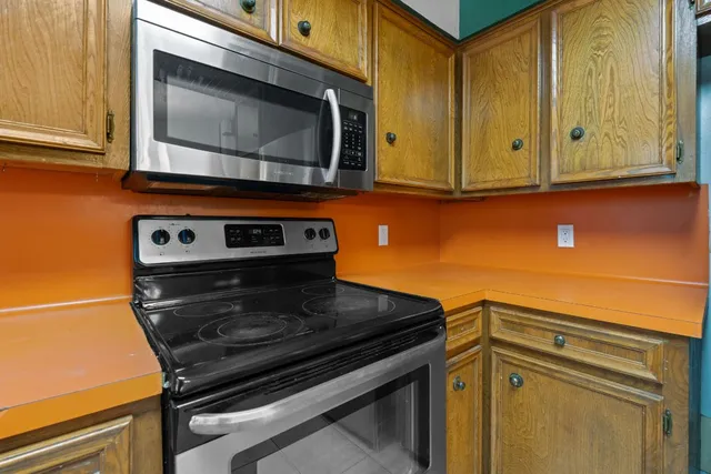 a kitchen with granite countertop cabinets stainless steel appliances and a counter space