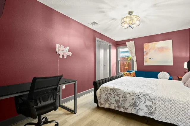 a bedroom with a bed a desk and chair