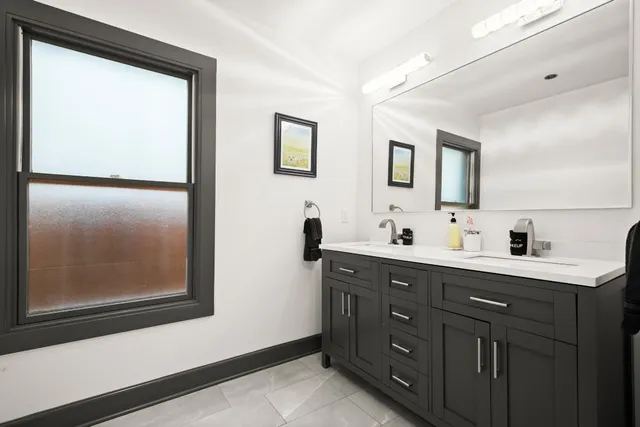 a bathroom with a double vanity sink and mirror
