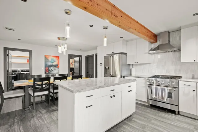 a kitchen with stainless steel appliances granite countertop a stove and cabinets