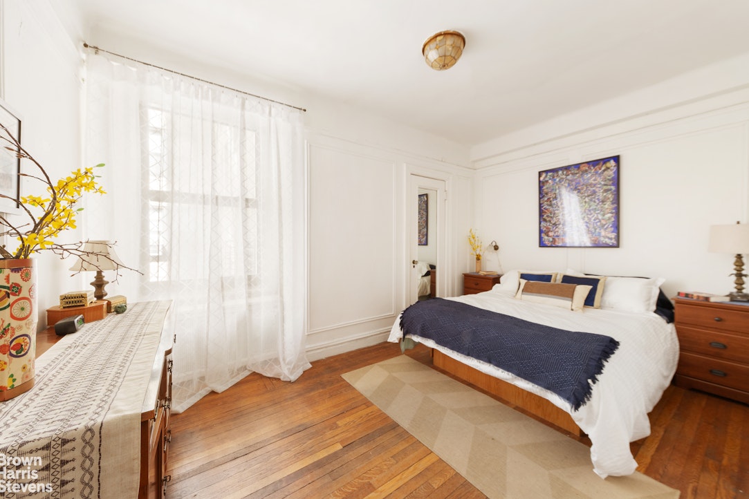 395 Riverside Drive, Unit 1D Manhattan, NY 10025 - Photo 2 of 9 a bedroom with a bed and a painting on the wall