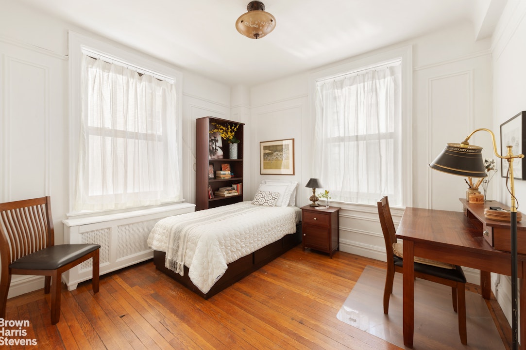 395 Riverside Drive, Unit 1D Manhattan, NY 10025 - Photo 3 of 9 a bedroom with a bed and a table in it