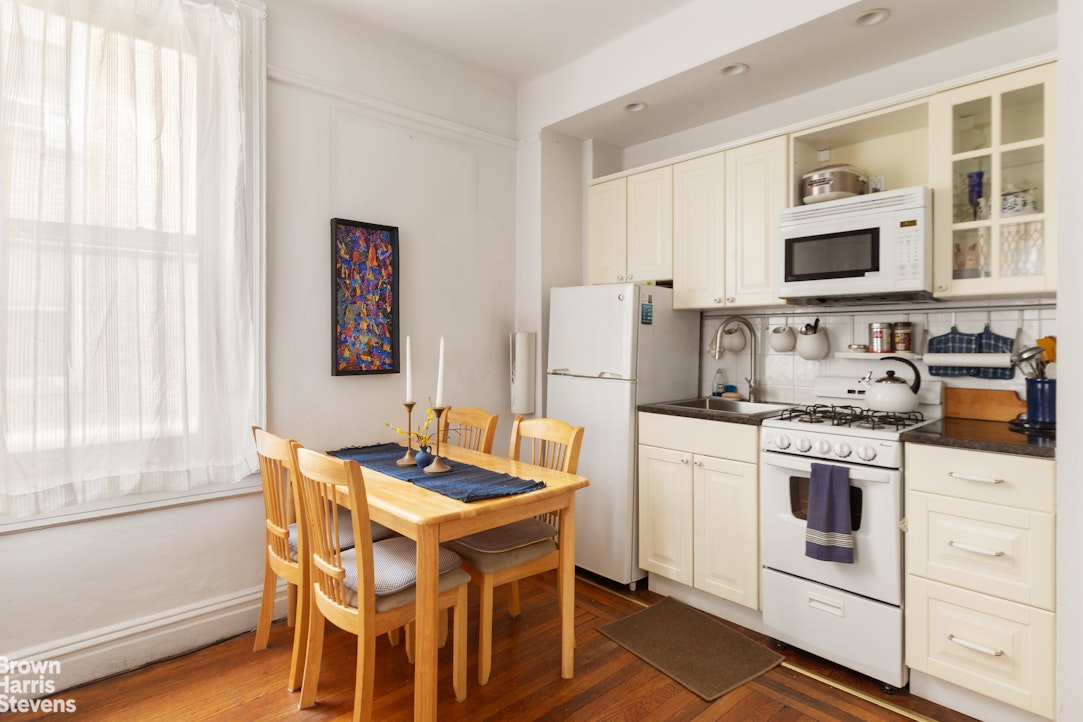 395 Riverside Drive, Unit 1D Manhattan, NY 10025 - Photo 5 of 9 a kitchen with stainless steel appliances granite countertop a white cabinets and a stove top oven