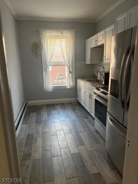 a kitchen with a refrigerator a stove top oven a sink and a window