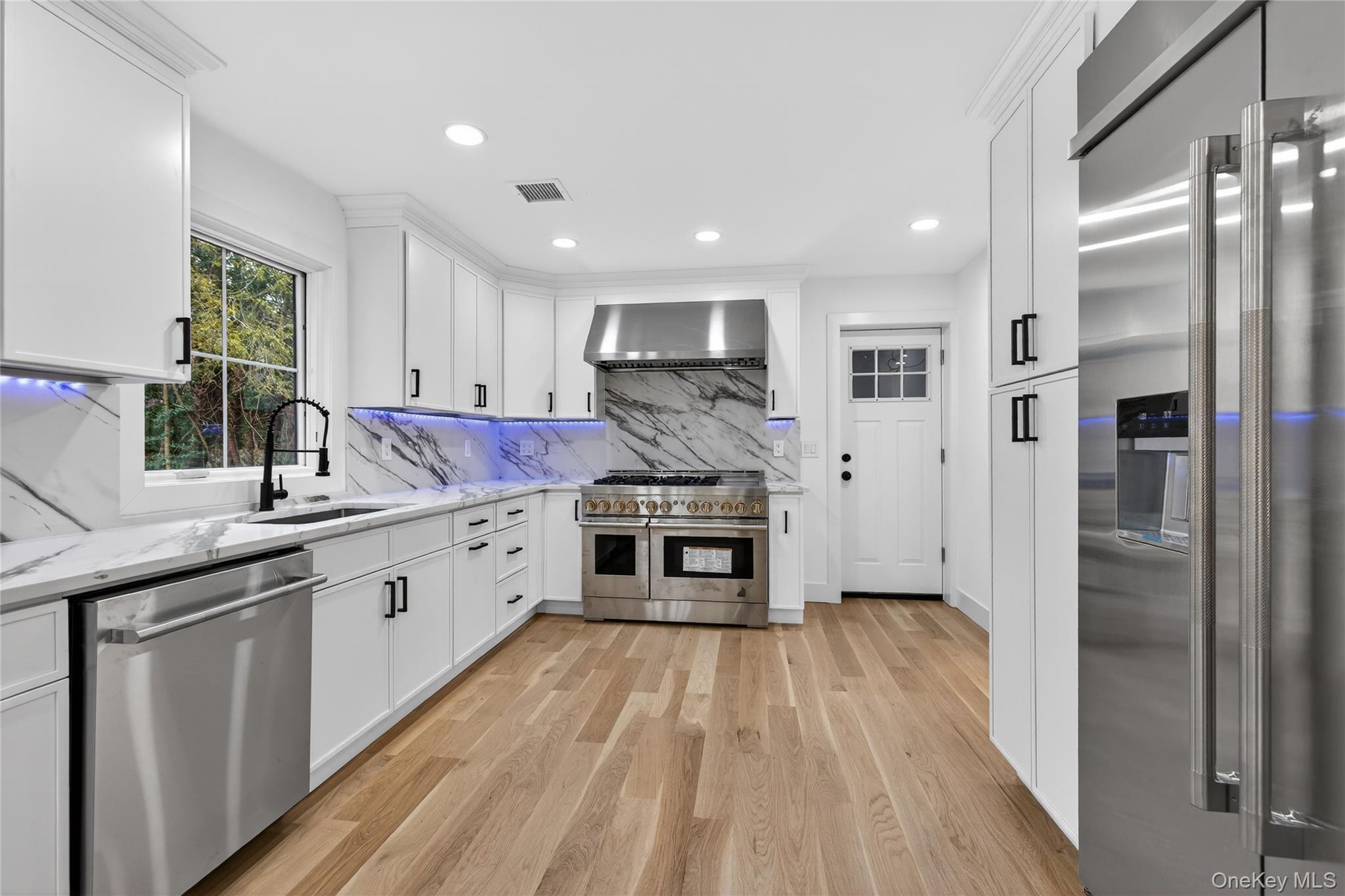 199 Salem Road East Hills, NY 11577 - Photo 7 of 40 Kitchen with high quality appliances, white cabinets, light wood-style floors, light stone counters, and recessed lighting