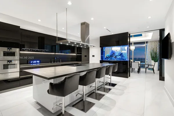 a kitchen with stainless steel appliances kitchen island a table and chairs in it