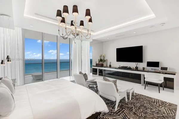 a bedroom with a bed and a chandelier