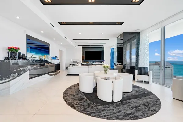 a living room with couches a fireplace and a kitchen island