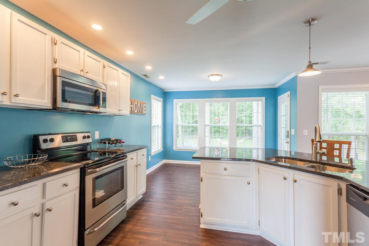 5216 Cardinal Grove Boulevard Raleigh, NC 27616 - Photo 11 of 25 a kitchen with stainless steel appliances granite countertop a stove a sink and a microwave