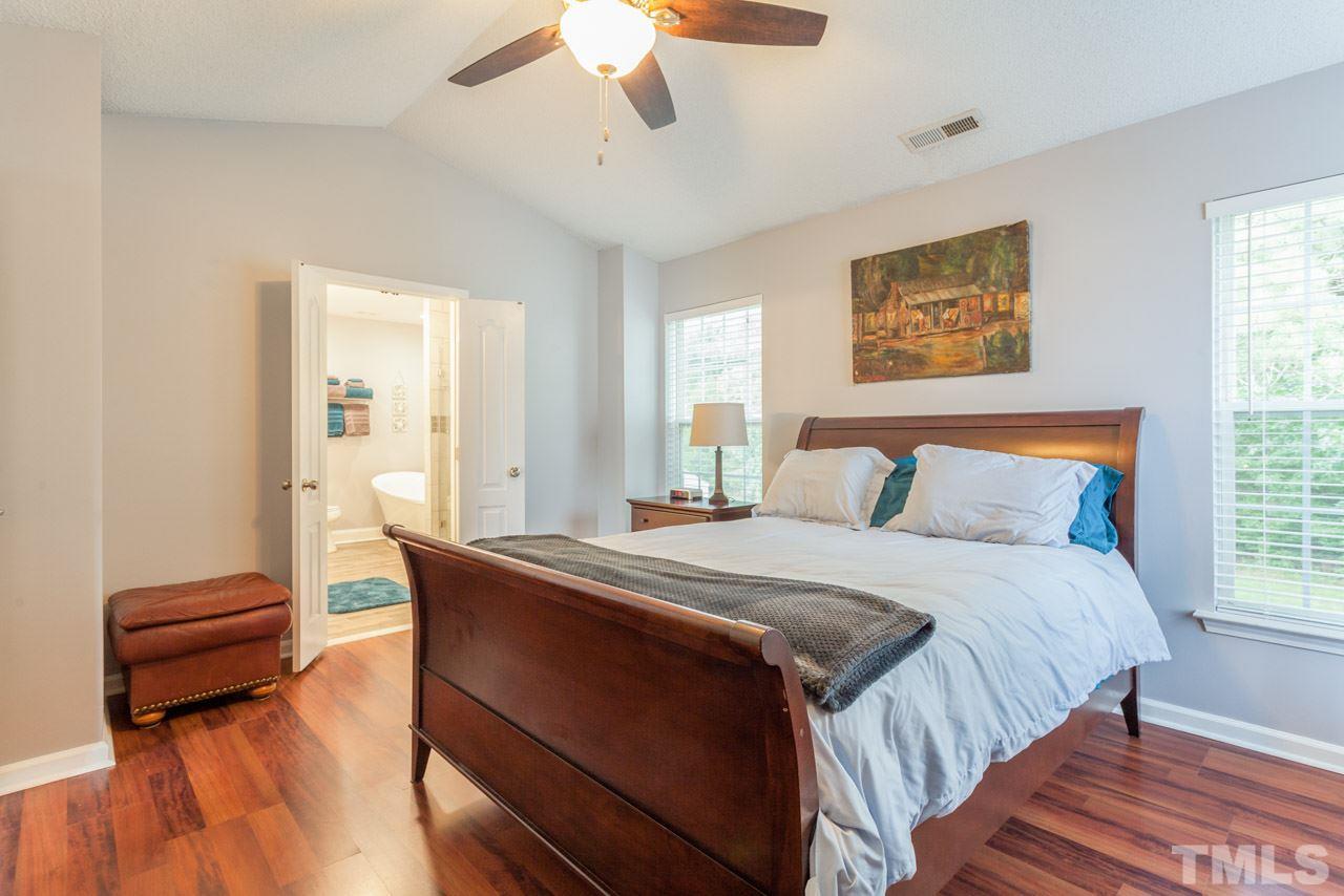 5216 Cardinal Grove Boulevard Raleigh, NC 27616 - Photo 14 of 25 a bedroom with a bed and a chandelier