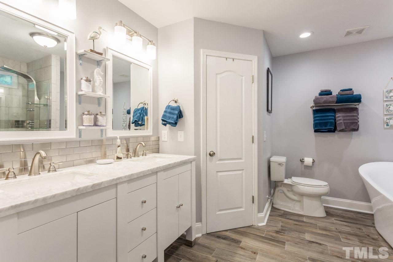 5216 Cardinal Grove Boulevard Raleigh, NC 27616 - Photo 16 of 25 a bathroom with a sink a toilet and a large mirror