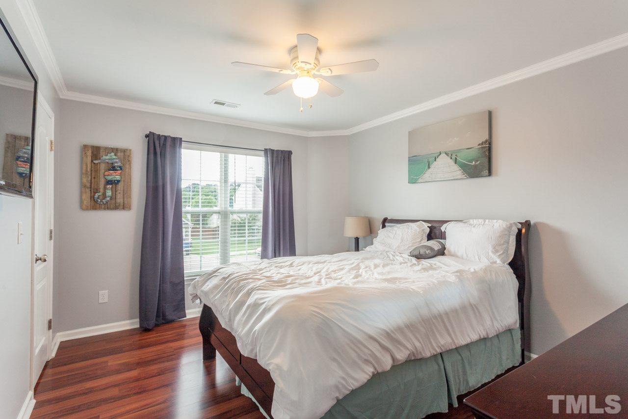 5216 Cardinal Grove Boulevard Raleigh, NC 27616 - Photo 18 of 25 a bedroom with a large bed and a chandelier
