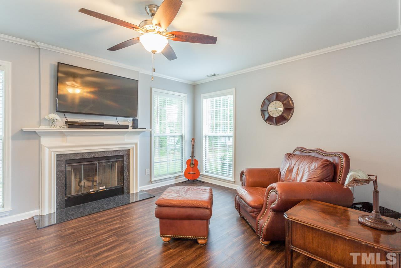 5216 Cardinal Grove Boulevard Raleigh, NC 27616 - Photo 7 of 25 a living room with furniture a flat screen tv and a fireplace