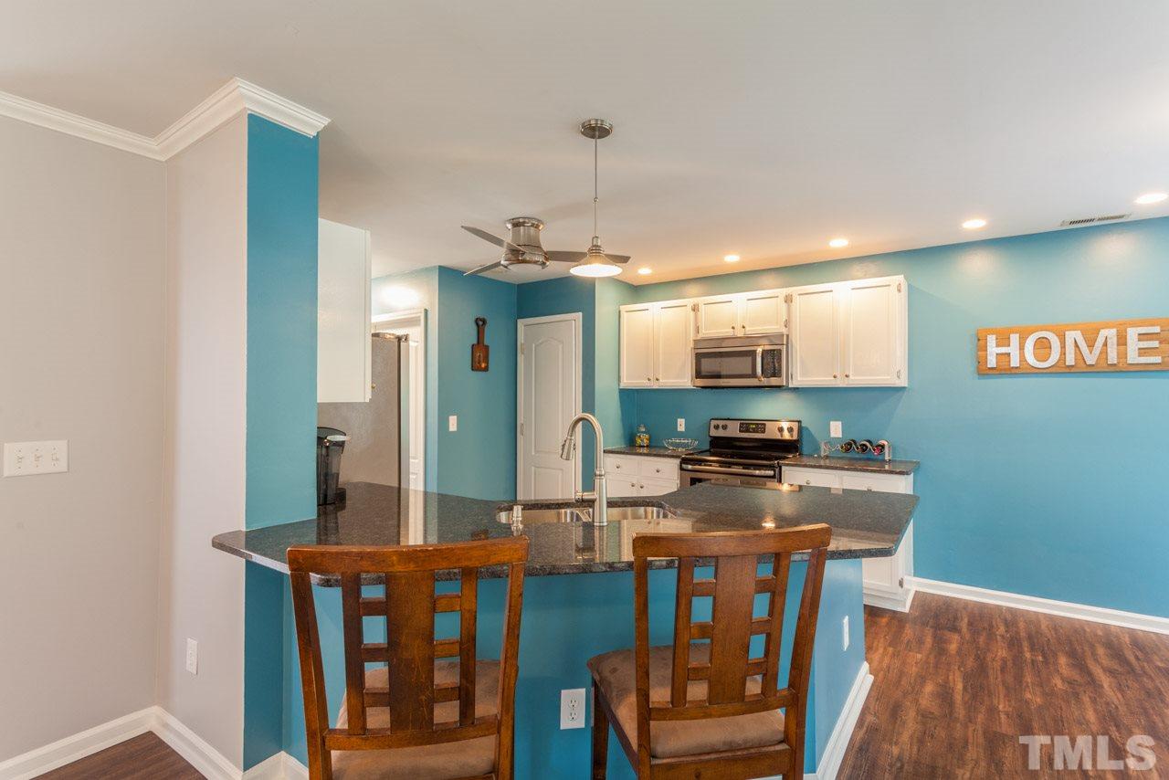 5216 Cardinal Grove Boulevard Raleigh, NC 27616 - Photo 9 of 25 a kitchen with stainless steel appliances granite countertop a stove and a wooden floors