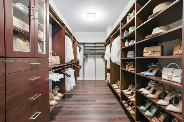 a view of walk in closet with clothes and shoes